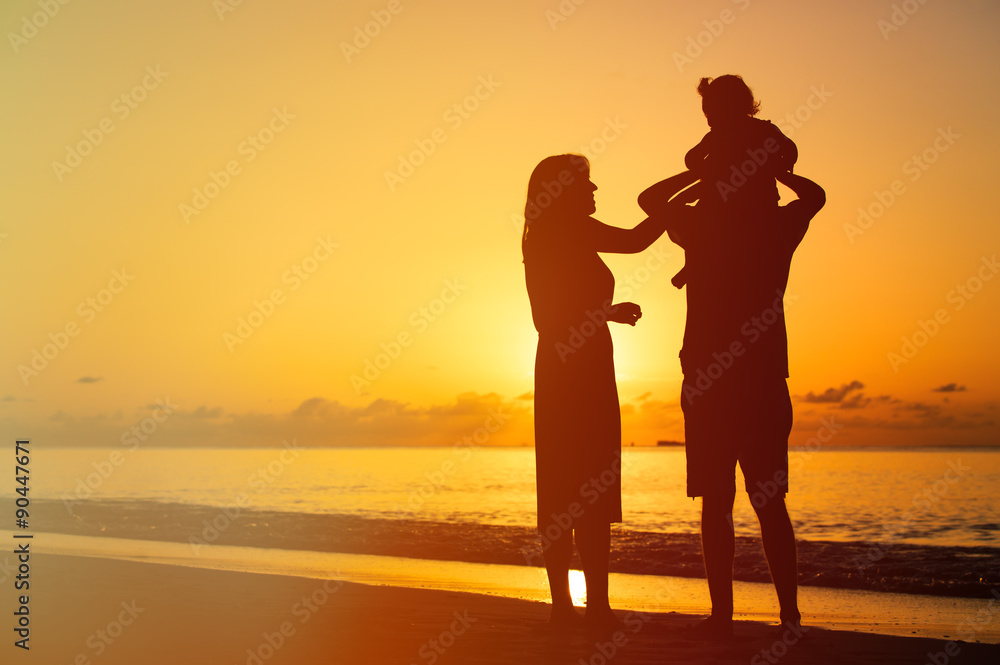 happy couple with little child at sunset