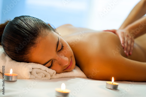 Attractive young woman having relaxing massage in spa.