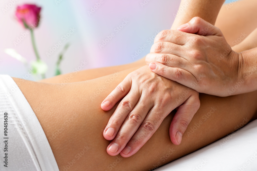 Naklejka premium Detail of Hands massaging female hamstrings.