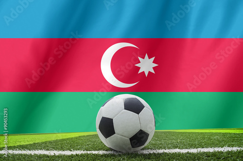 Soccer ball and national flag of Azerbaijan lies on the green gr