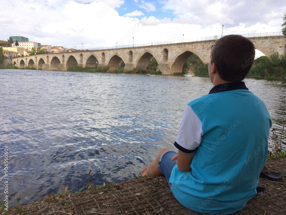 joven descansando a la orilla del rio con los pies en el agua joven descansando a la orilla del rio con los pies en el agua