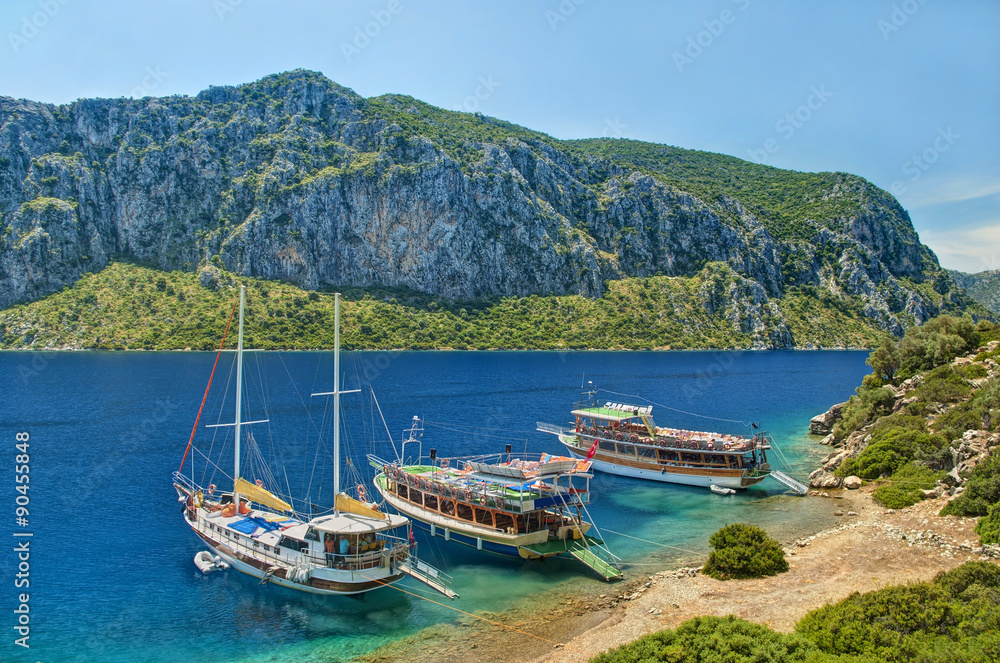 three tourist boats moored at island