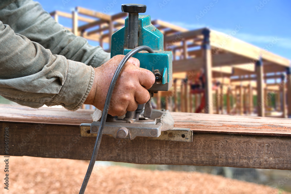 Man carpenter  cutting wood with electric saw, for  Home Building