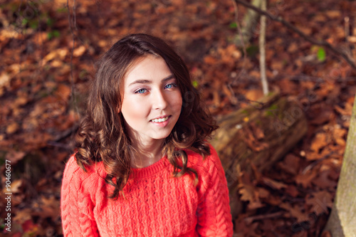 Portrait of young smiling girl in the autumn forest