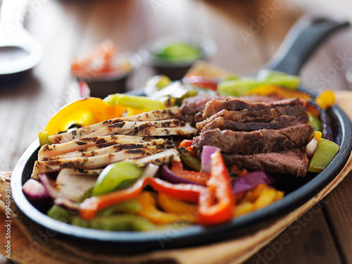 Fotografia steak and chicken fajitas close up in cast iron fajita skillet