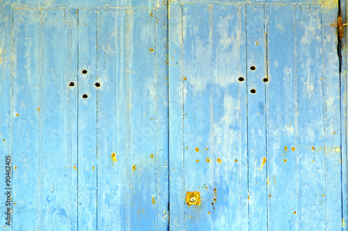 stripped paint in the blue wood door  rusty nail photo