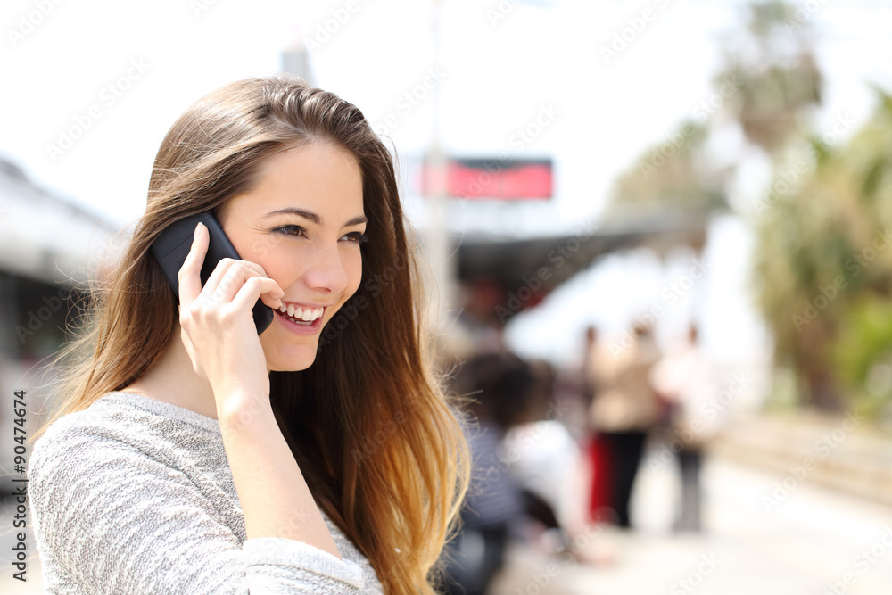 Woman talking on the phone waiting in a train station Woman talking on the phone waiting in a train station