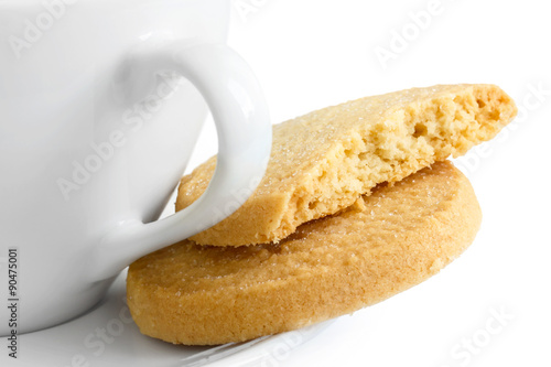 Detail of a white ceramic cup with shortbread biscuits.