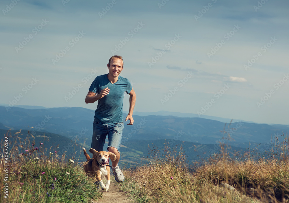 Man running with his dog on the mountain tableland.