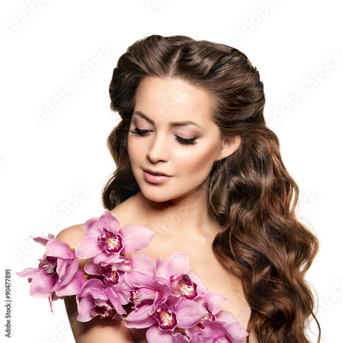 Beauty young woman  luxury long curly hair with orchid flower. H