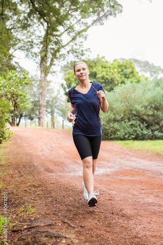 Athletic woman running on a footpath