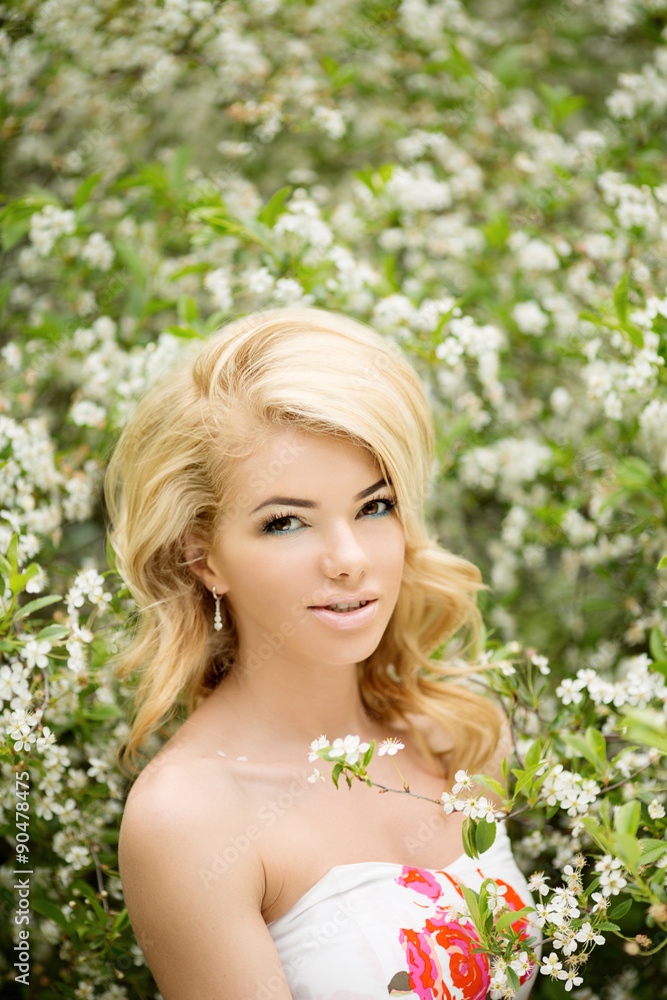 Young spring fashion woman. Trendy girl in the flowering trees i Young spring fashion woman. Trendy girl in the flowering trees i