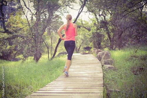 Blonde athlete jogging on wooden path © WavebreakMediaMicro