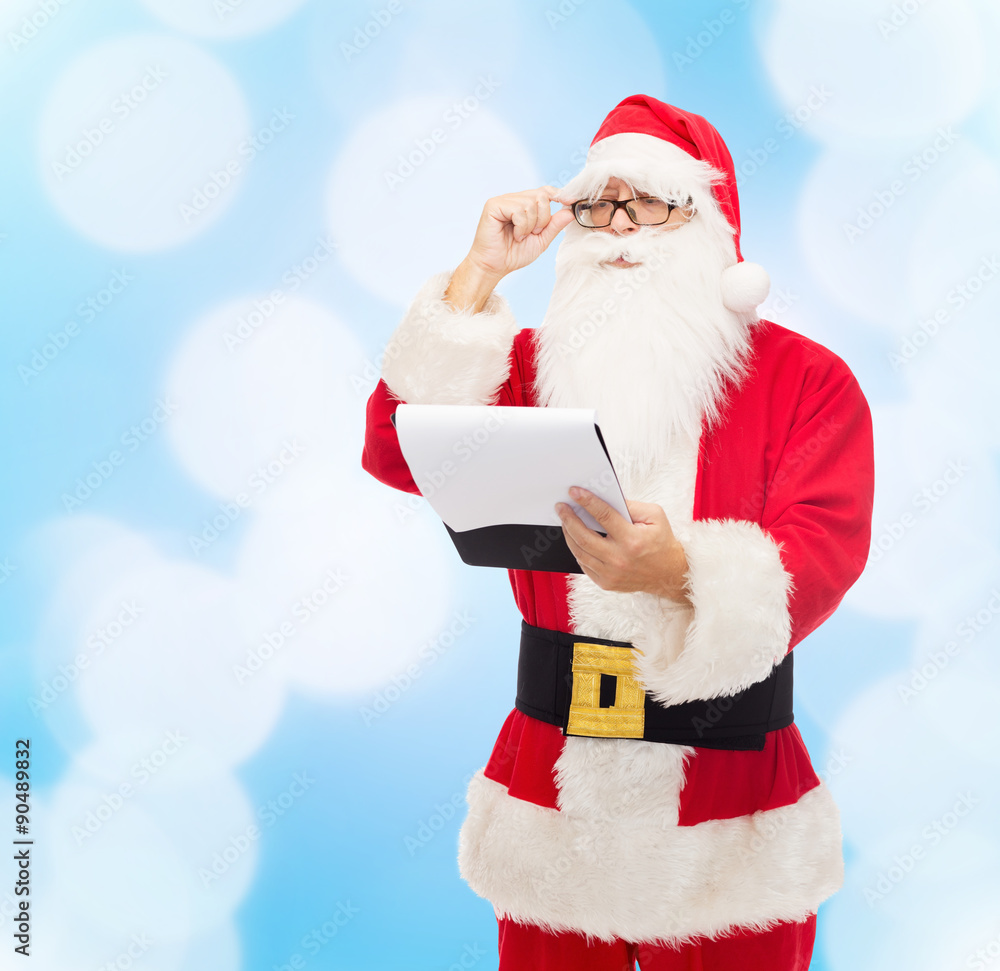 man in costume of santa claus with notepad man in costume of santa claus with notepad