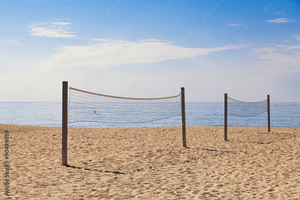Two nets for beach voleyball with sea in the background Two nets for beach voleyball with sea in the background