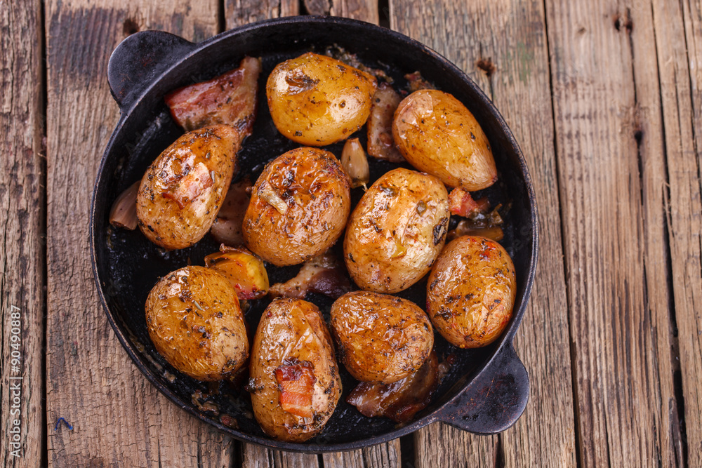 Roasted young potatoes in a pan with garlic and bacon.selective focus