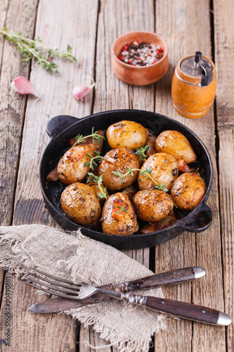 Young potatoes fried in a pan. With garlic, pancetta and thyme.selective focus