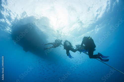 Divers decompressing underwater on a rope photo