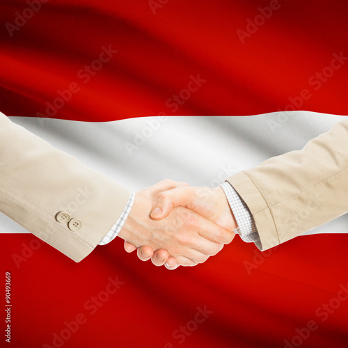 Businessmen handshake with flag on background - Austria