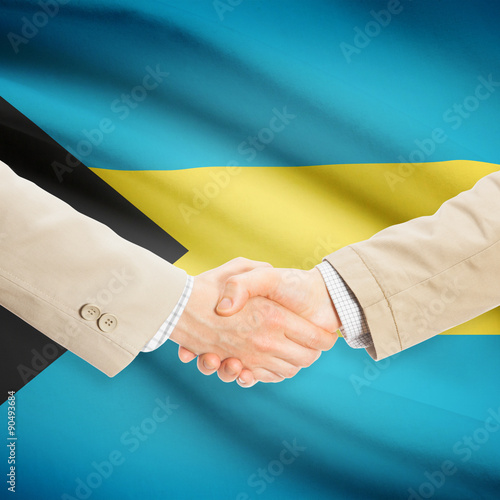 Businessmen handshake with flag on background - Bahamas