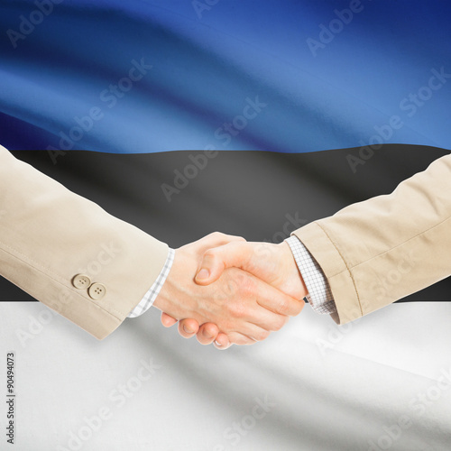 Businessmen handshake with flag on background - Estonia