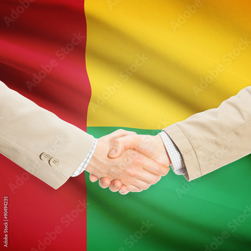 Businessmen handshake with flag on background - Guinea-Bissau