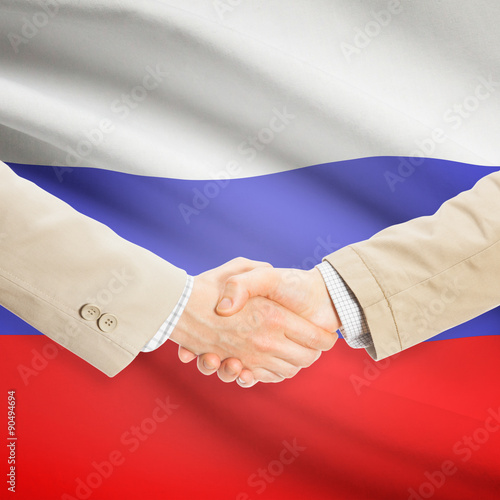 Businessmen handshake with flag on background - Russia