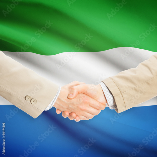 Businessmen handshake with flag on background - Sierra Leone