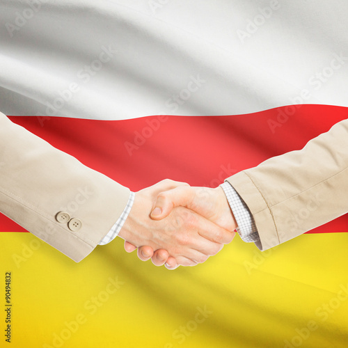 Businessmen handshake with flag on background - South Ossetia