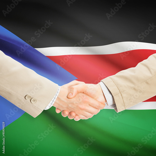 Businessmen handshake with flag on background - South Sudan