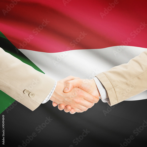 Businessmen handshake with flag on background - Sudan
