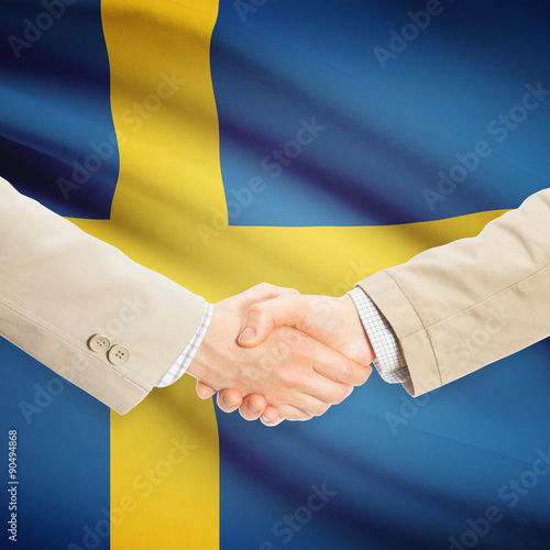 Businessmen handshake with flag on background - Sweden