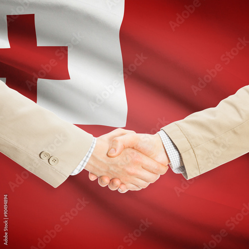 Businessmen handshake with flag on background - Tonga