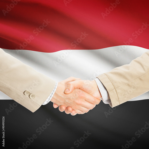 Businessmen handshake with flag on background - Yemen