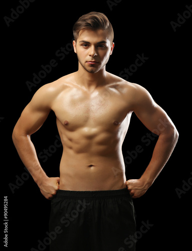 Muscle young man on dark background © Africa Studio