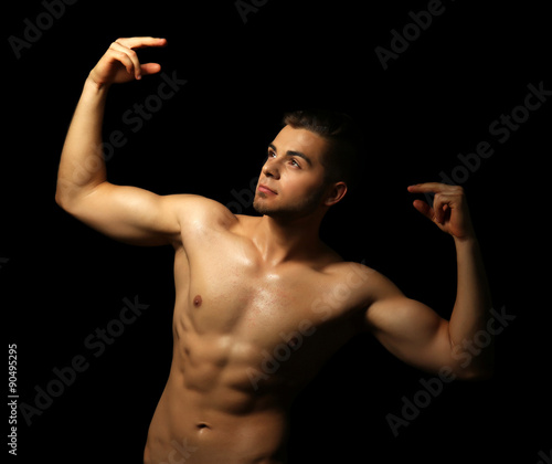 Muscle young man on dark ba...