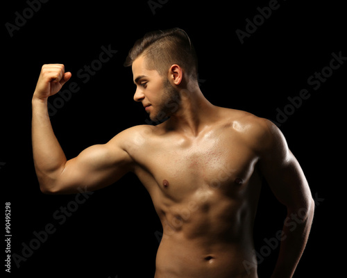 Muscle young man on dark ba...
