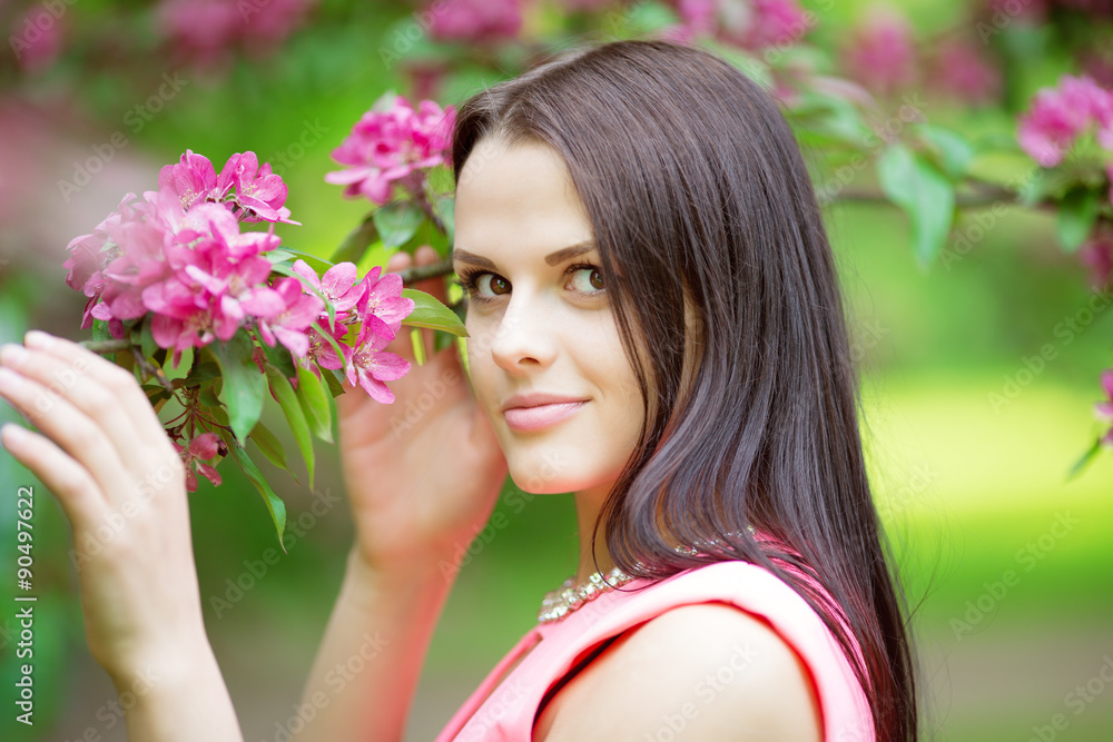 Young spring fashion woman. Trendy girl in the flowering trees in the spring summer garden. Springtime or summertime. Lady in spring landscape background. Allergic to pollen of flowers. Spring allergy Young spring fashion woman. Trendy girl in the flowering trees in the spring summer garden. Springtime or summertime. Lady in spring landscape background. Allergic to pollen of flowers. Spring allergy