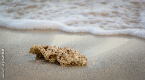 Small rock washed away in white sand