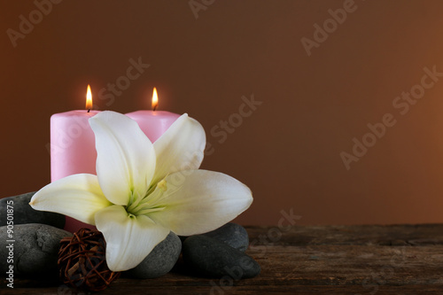 Beautiful spa composition with lily on brown background