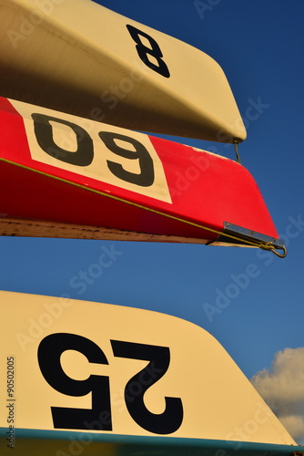 Coxes four competitive rowing boats, U.K.  An abstract image of stacked boats on racks lit by a setting Sun with racing numbers not licence plates. photo