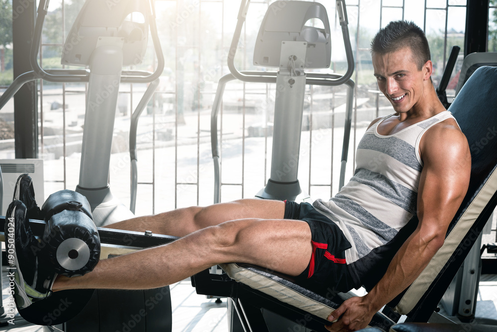 Man doing leg extension in gym Man doing leg extension in gym