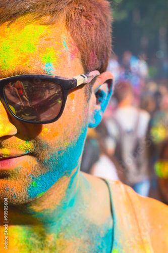 Portrait of a young haooy man in the Holi festival of color photo