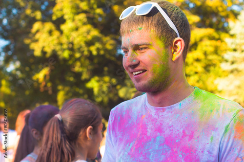 Portrait of a young haooy man in the Holi festival of color photo