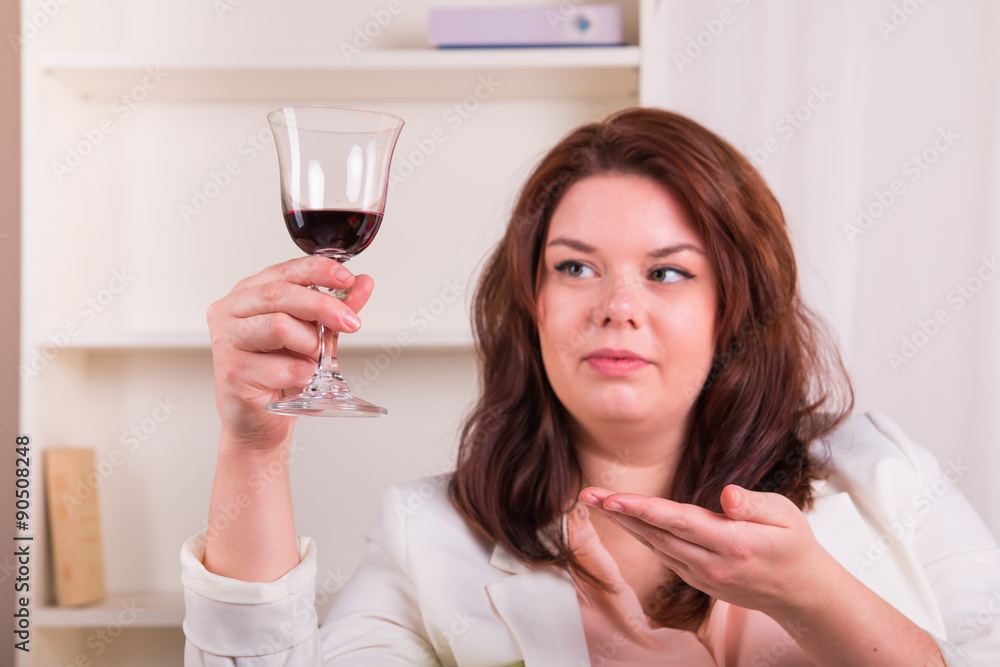 Woman at home tests glass of red wine