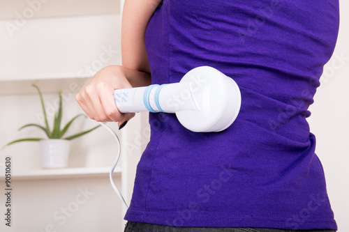 Woman massaging the body with infrared lamps massager photo