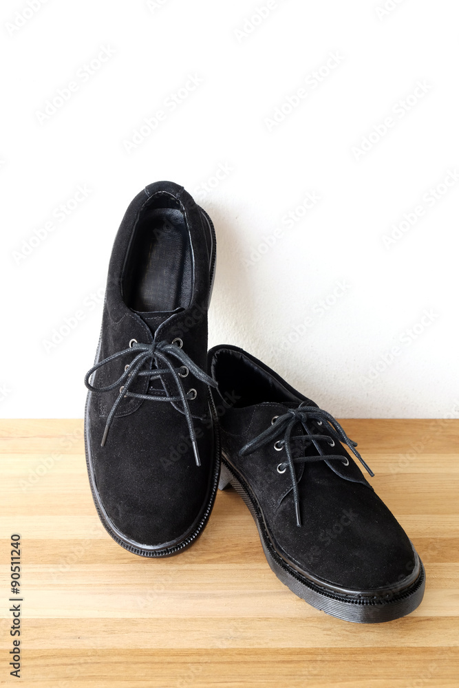 Black leather shoes on wood shelf background Black leather shoes on wood shelf background