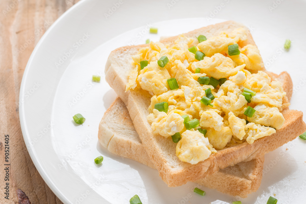 Scrambled eggs on toast, garnished with onion. Scrambled eggs on toast, garnished with onion.