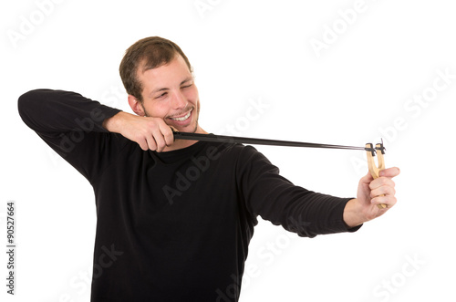 Hansome man concentrated aiming a slingshot isolated over white