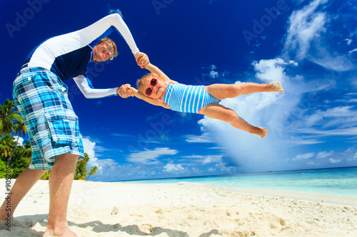 father and little daughter having fun on beach